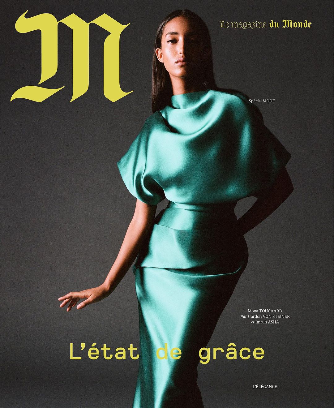 Magazine cover featuring a woman wearing a green dress, posing in front of a grey background. The magazine's title is in yellow.