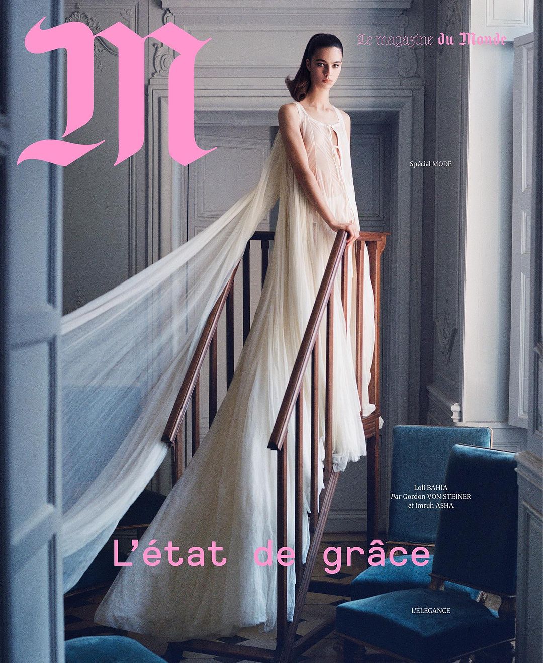 Fashion editorial magazine cover featuring a model in a sheer gown, posing on stairs in an elegant interior setting with pink masthead.
