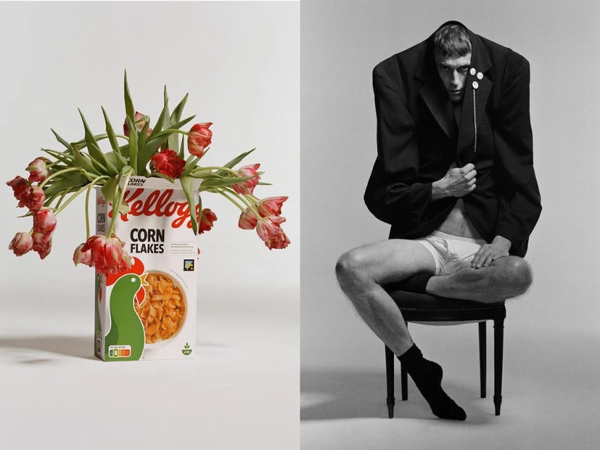 Surreal studio portrait: Man in oversized jacket seated next to corn flakes box vase holding tulips, set against a neutral backdrop.
