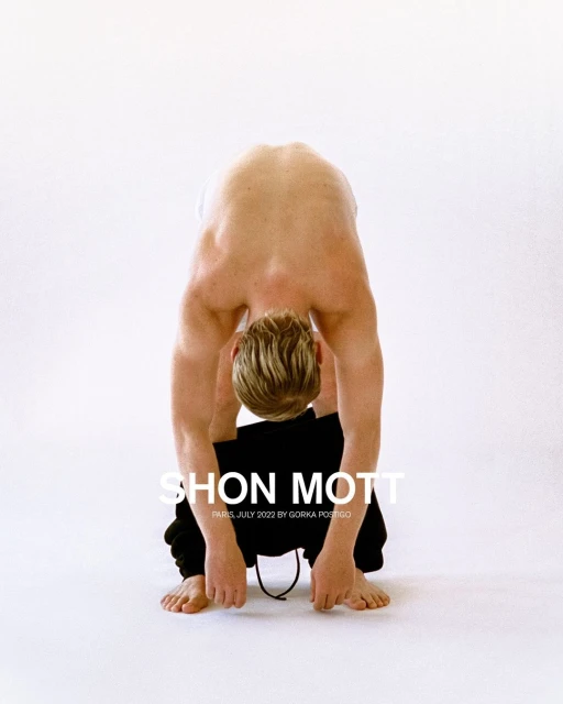 Nude man bends over, head between legs, wearing sweatpants; a fashion shot with the 'SHON MOTT' logo over a white background.