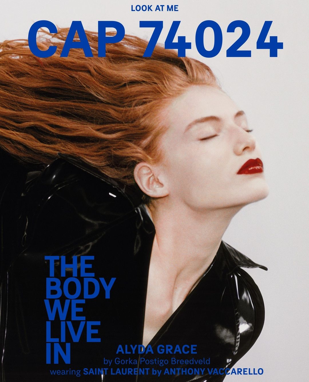 Fashion magazine cover featuring a fair-skinned woman with red hair, red lipstick, and a black patent leather jacket against a light gray background.