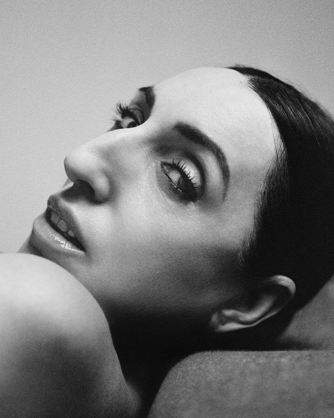 Close-up monochrome portrait of a woman looking back over her shoulder by photographer Gorka Postigo