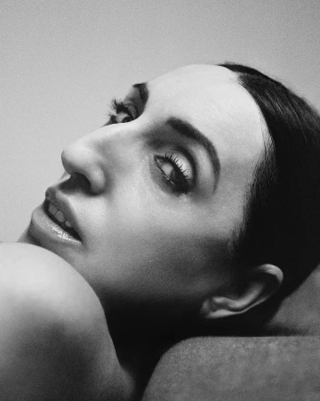 Close-up monochrome portrait of a woman looking back over her shoulder by photographer Gorka Postigo