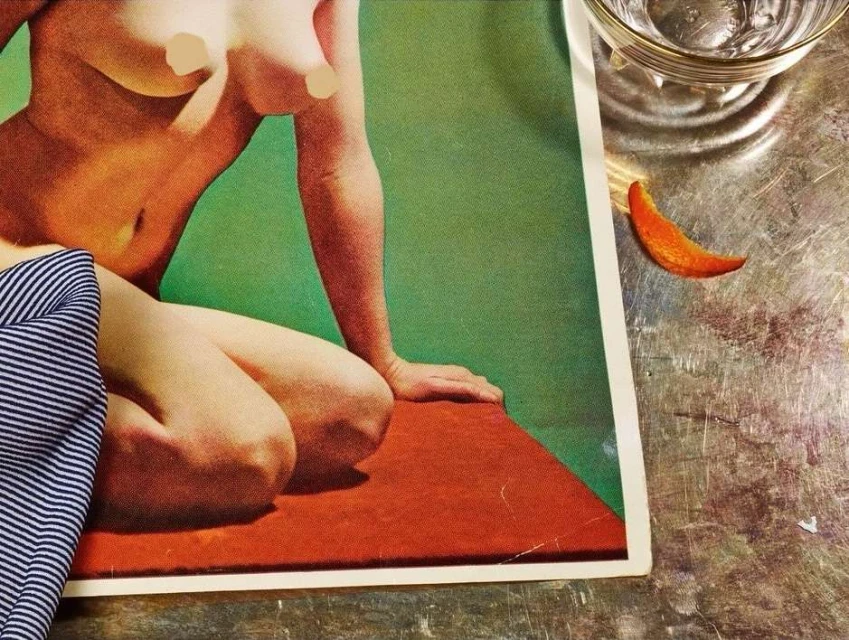 Nude figure illustration on a vintage magazine cover with a glass of water and citrus peel on a metallic surface. 