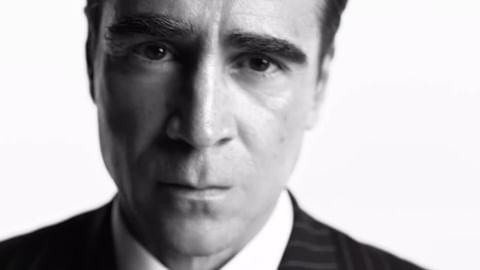 Close-up portrait of Colin Farrell in a dark pinstripe suit against a stark white background captured by Gray Sorrenti.
