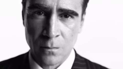 Close-up portrait of Colin Farrell in a dark pinstripe suit against a stark white background captured by Gray Sorrenti.