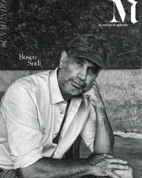 Monochrome portrait of a middle-aged man wearing a baseball cap and button-down shirt, resting his chin on his hand.