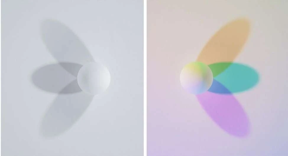 Still life of a white sphere casting colorful shadows on a white surface. Two images side by side, one with grey shadows, one with color.