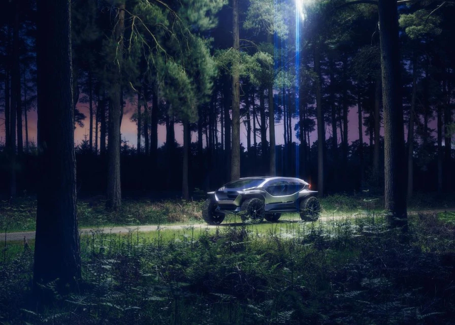 Futuristic silver off-road vehicle in a dense forest with tall trees and ferns, illuminated by a bright light from above. Automotive.