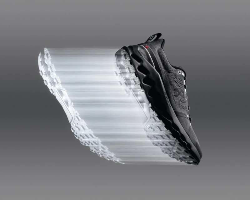 Motion blur photo of a single On trail running shoe, floating against a gray background, showcasing athletic design and technology.