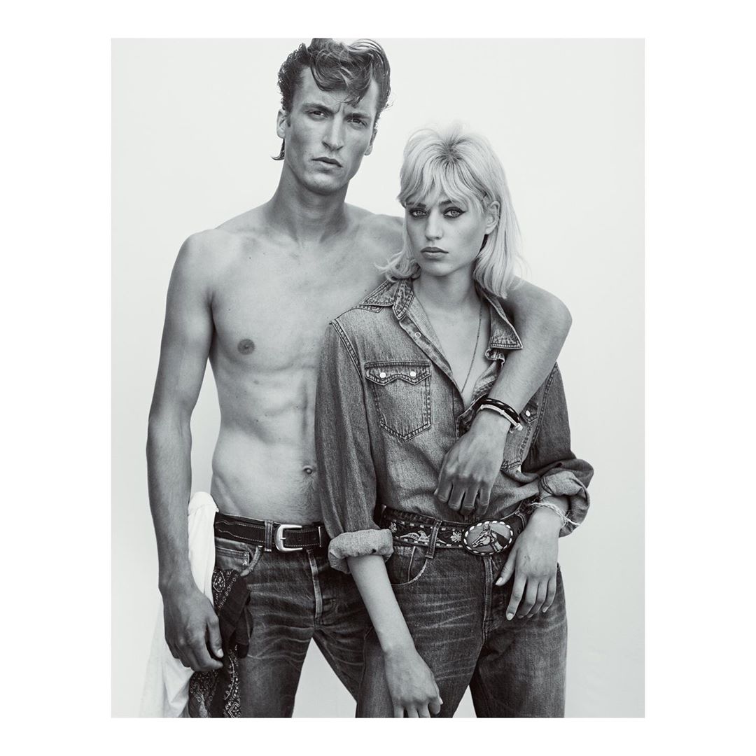 Black and white portrait of a shirtless man with dark hair and a blonde woman wearing a denim shirt, photographed by Gregory Harris.