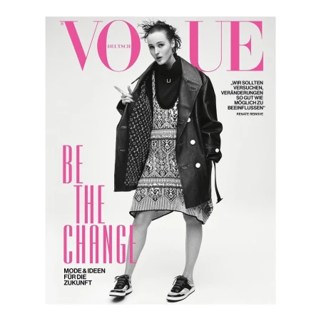 Vogue Deutsch cover featuring a young woman in a black coat and patterned dress, posing confidently against a clean, white backdrop.