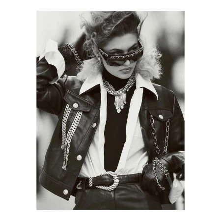 Black and white editorial portrait of a woman wearing leather jacket, chain-embellished sunglasses, and layered necklaces by Gregory Harris.