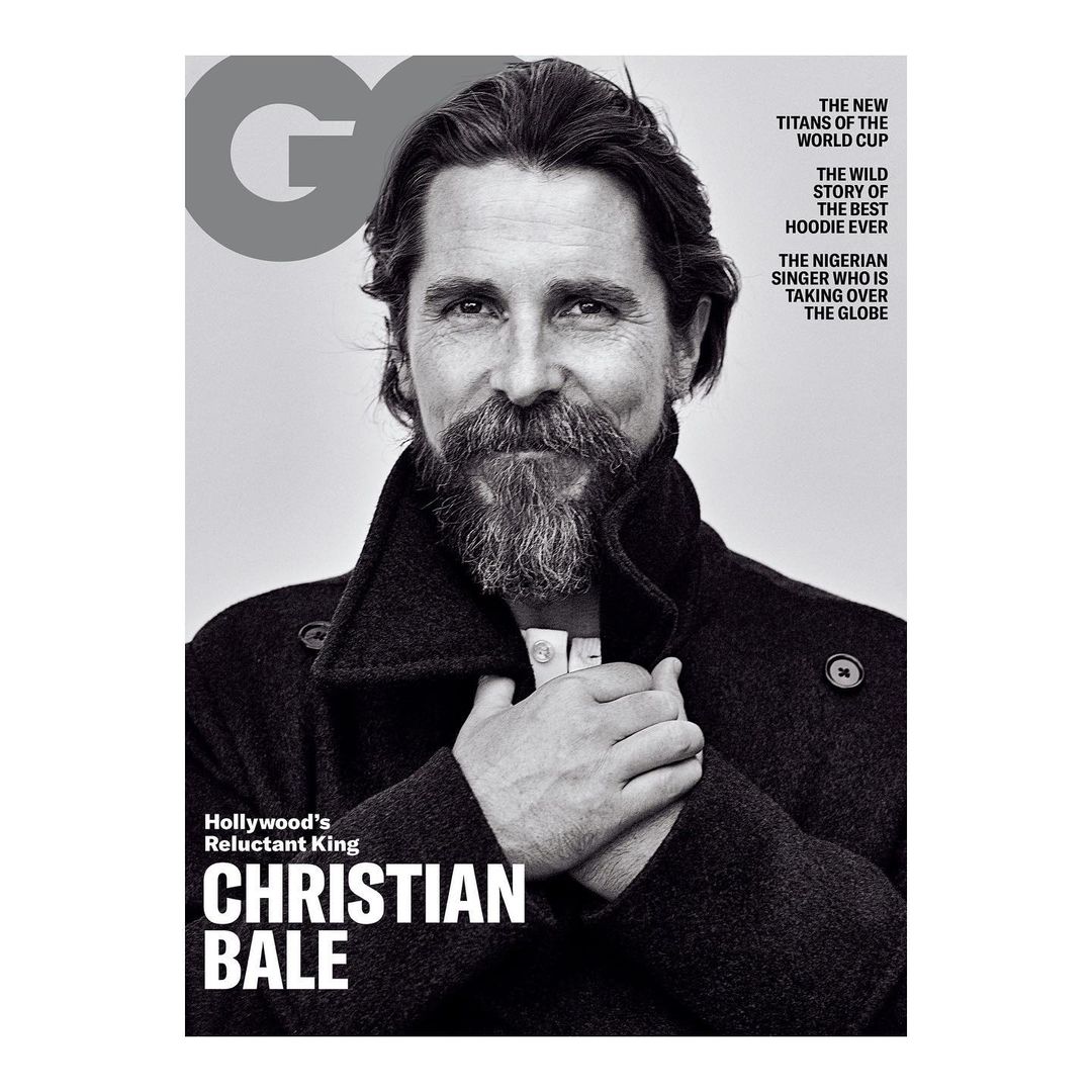 Black-and-white magazine cover featuring a portrait of actor Christian Bale in a dark coat, highlighted against a neutral background.