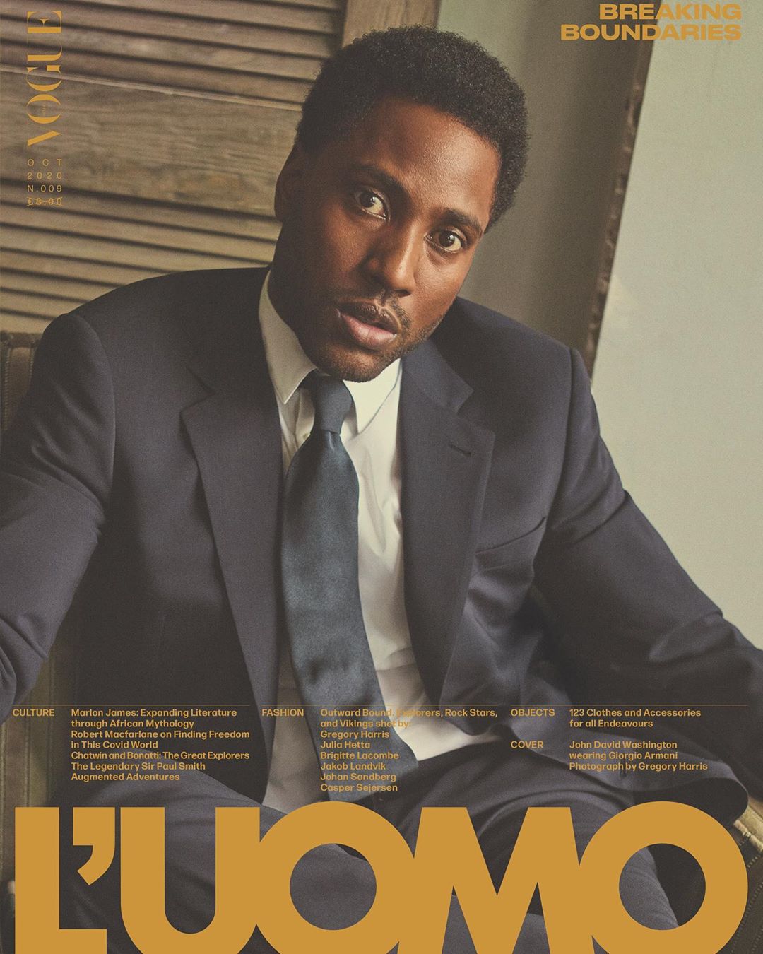 Magazine cover featuring a portrait of a Black man in a suit and tie, with the title 'L'UOMO VOGUE' visible in large gold letters.