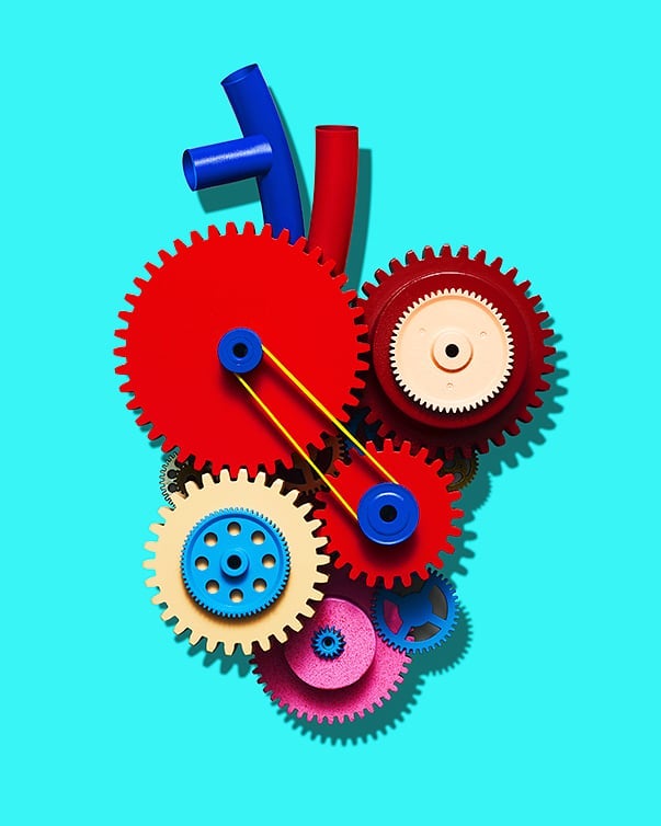 Dynamic mechanical heart illustration on a light turquoise background with blue and red tubes and interconnected, colorful gears.
