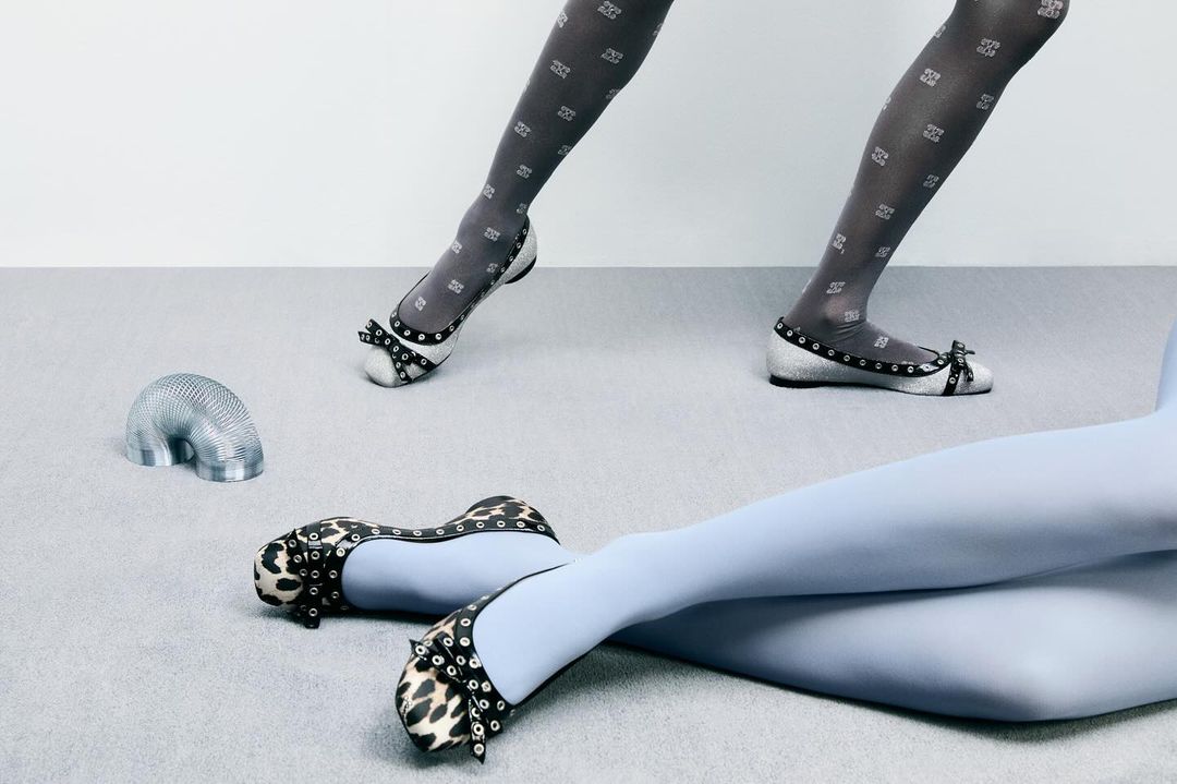 Fashionable footwear and patterned tights showcased in a studio setting, featuring ballet flats with embellishments and a metallic slinky toy.