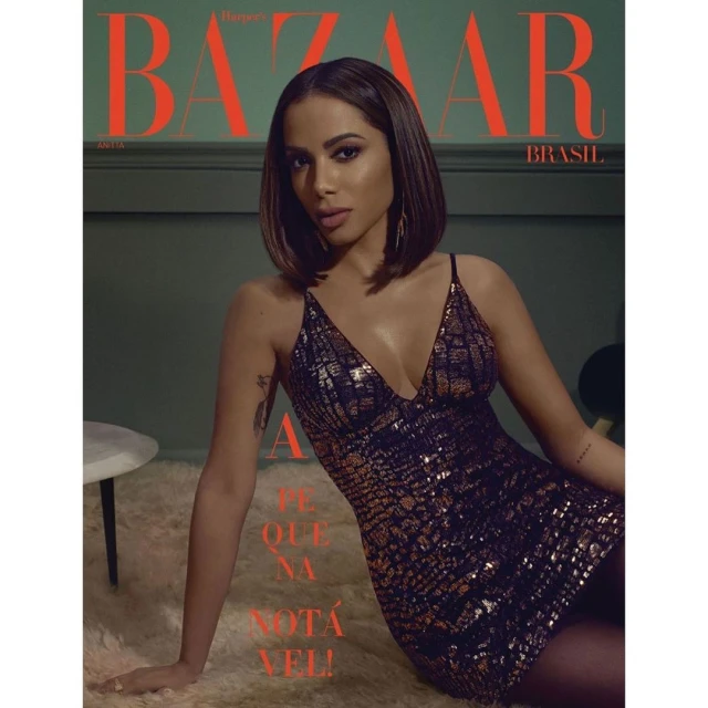 Brazilian magazine cover featuring Anitta, a solo adult female model with medium brown hair, in a black and gold dress on a white rug.