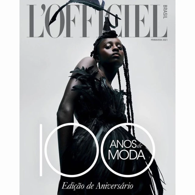 L'Officiel Brasil magazine cover featuring a model in a black feathered dress and headpiece against a white background.