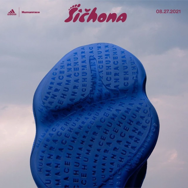 Close-up of a blue Adidas Humanrace Sichona shoe sole with logo against a neutral cloudy sky, promotional campaign image.