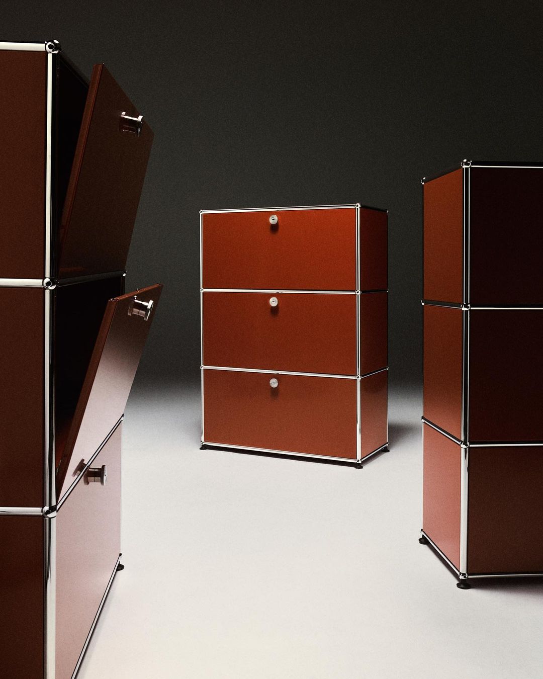 Modular brown storage units with silver trim, doors open on the stacked unit, against dark gray. Home storage and organization.