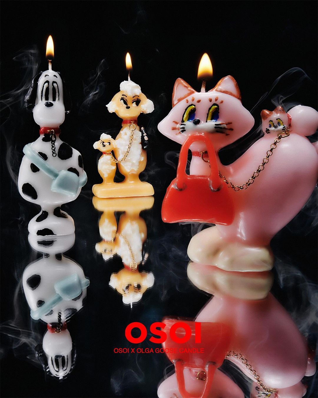 Three novelty candles shaped like cartoon animals—a dalmatian, poodle with toy poodle, and a cat with handbag—displayed with reflections.