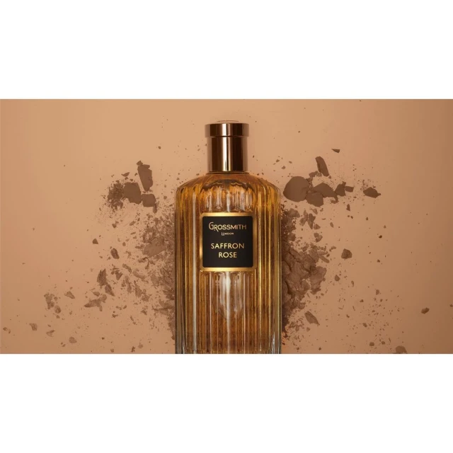 Grossmith Saffron Rose perfume bottle on a beige background with scattered powder for beauty and product marketing imagery.