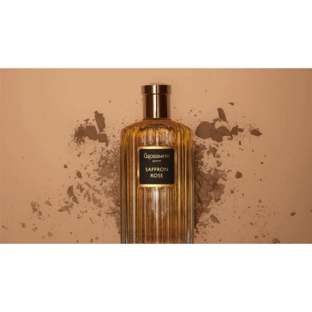 Grossmith Saffron Rose perfume bottle on a beige background with scattered powder for beauty and product marketing imagery.