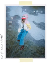 Child standing in puddles wearing a pastel hooded jacket, red bucket hat, and wide-leg denim jeans