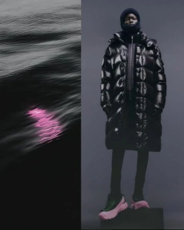 Fashion editorial shot of an African American model wearing a glossy black puffer coat, cap, and color-blocked platform sneakers against a dark backdrop.