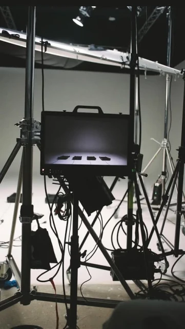 Briefcase on stand surrounded by lighting equipment in a photo studio. Studio lighting. Neutral tones. Professional photography.