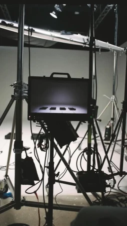 Briefcase on stand surrounded by lighting equipment in a photo studio. Studio lighting. Neutral tones. Professional photography.