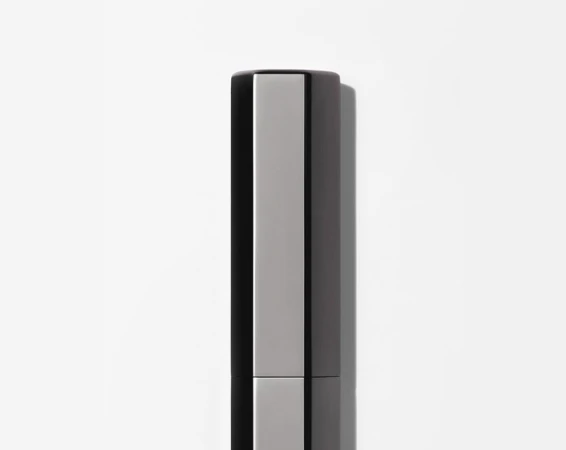 Close-up studio shot of sleek, modern silver and black cosmetic container against a bright white background, emphasizing minimalist design.