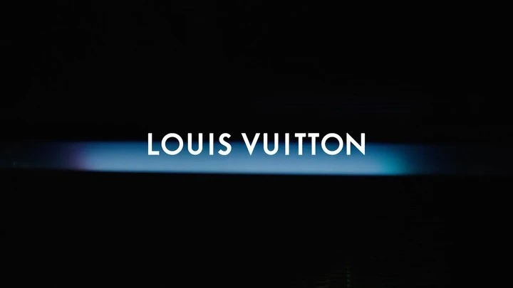 Louis Vuitton brand name in white against a dark background with a blue and purple horizontal gradient light.