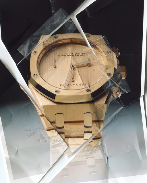 A close-up studio shot of an Audemars Piguet watch in gold, held together with tape and photographs, against a black background.