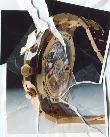 Close-up photograph of a gold Royal Oak wristwatch presented on a torn background, creating a visually striking juxtaposition.