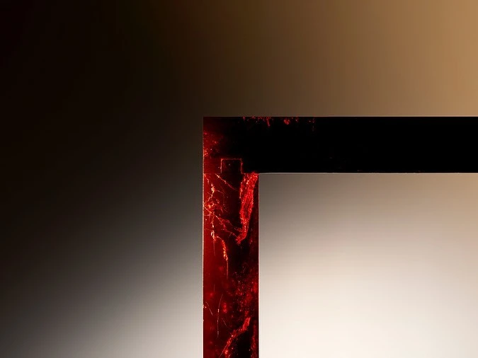 Abstract close-up of a dark rectangular frame with a cracked red texture against a gradient brown background, showcasing modern design.