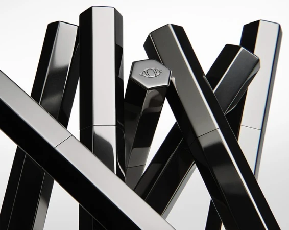 Abstract composition featuring several black, hexagonal cosmetic tubes arranged in a visually striking, geometric pattern on a white background.
