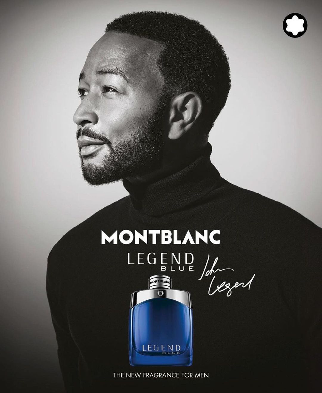Montblanc fragrance ad featuring John Legend in black turtleneck with a bottle of Legend Blue, set against a light grey backdrop.