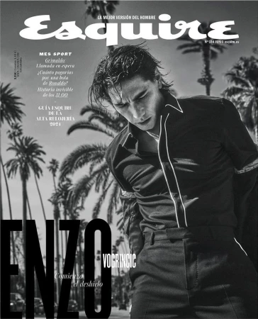 Monochrome magazine cover featuring Enzo Vogrincic in a dark shirt against a palm tree backdrop shot by Guy Aroch.