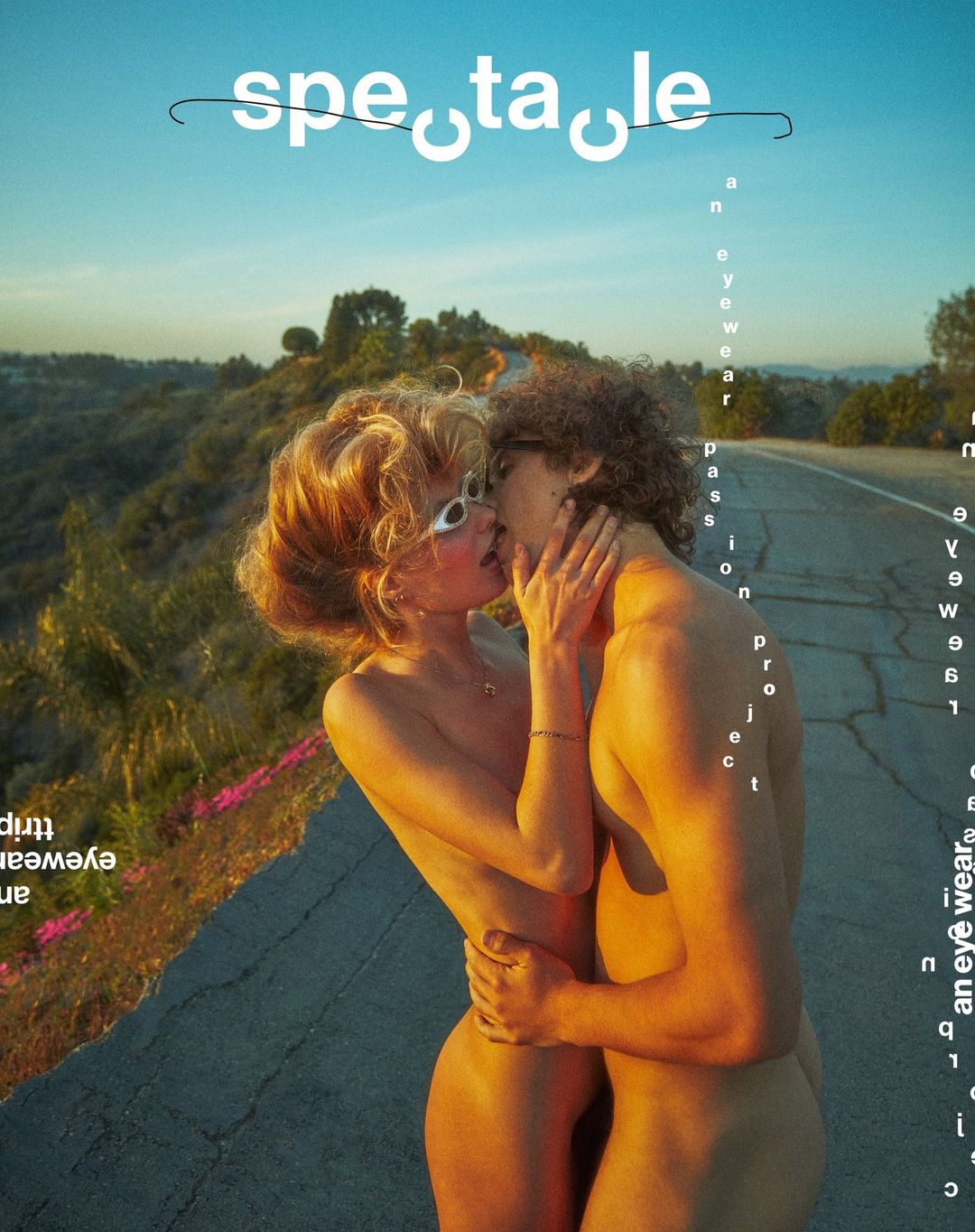 Topless couple kissing on a road at daytime in warm light. The female model wears eyewear. Image is a magazine cover.