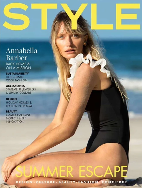 Magazine cover featuring Annabella Barber in a black swimsuit, seated on a beach with a blue sky and ocean backdrop. The cover text includes 'STYLE'.