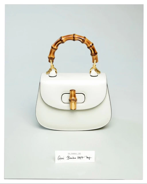 Elegant white leather Gucci Bamboo 1947 handbag featuring a distinctive bamboo handle, displayed in a product shot against a pale gray background.