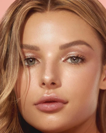 Close up beauty portrait of a woman with glowing skin, blonde hair, and glossy pink lips photographed by Hai Ngo.