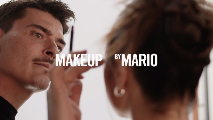 Makeup artist applying makeup to a model in a brightly lit studio, featuring close-up shot and 'Makeup by Mario' text overlay.