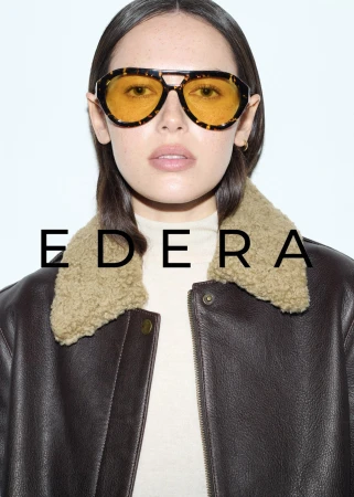 Woman with brown hair, wearing a leather jacket and glasses, posing against a white background, featuring the 'EDERA' brand.