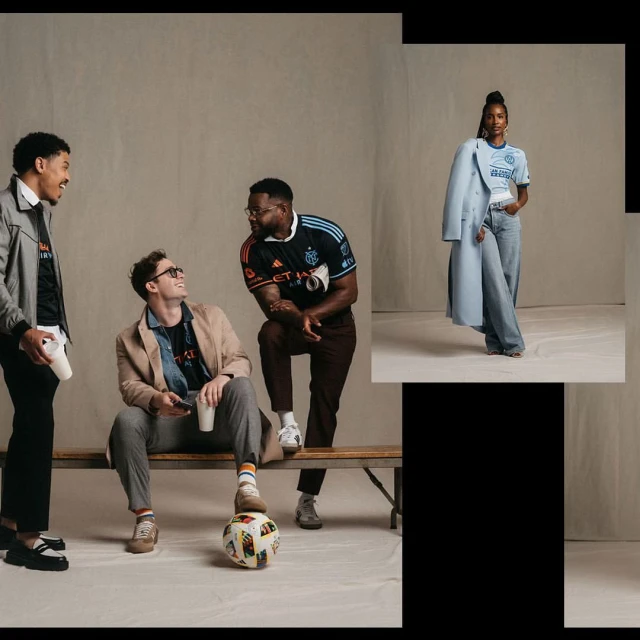 Four people are posed in a light studio with a soccer ball near a wood bench wearing soccer jerseys and casual wear. Fashion shoot.