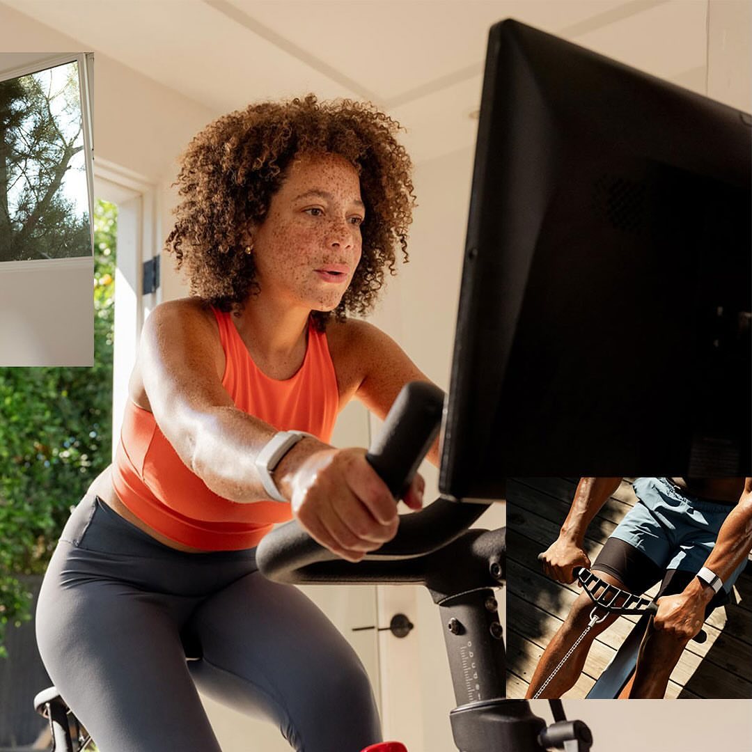 A woman with curly hair exercises on a stationary bike in an indoor setting, focusing on fitness and wellness.