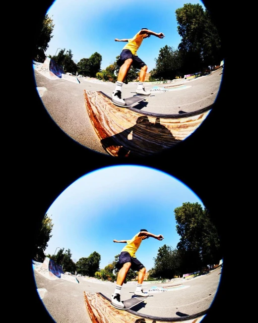 Action shot of a skateboarder performing a trick on a ramp at an outdoor skatepark on a clear sunny day with green trees in the background.