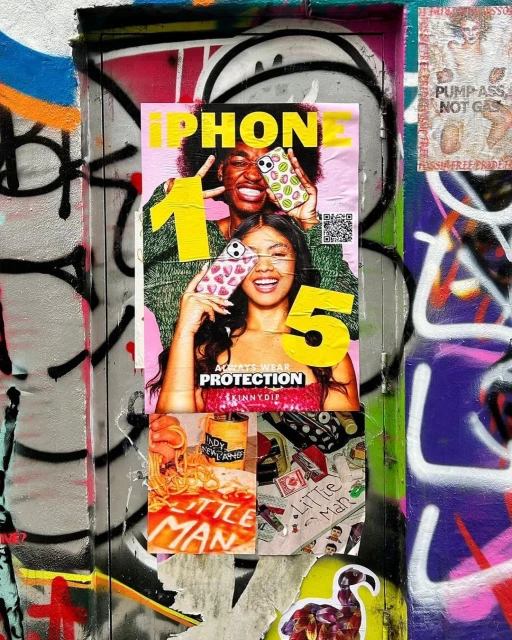 Outdoor shot of iPhone 15 advertisement featuring two people holding phone cases with smiling faces, layered on a graffiti-covered wall.